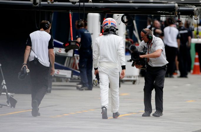 McLaren Honda Formula One driver Jenson Button of Britain walks to his team garage during the qualifying session of the Australian F1 Grand Prix at the Albert Park circui