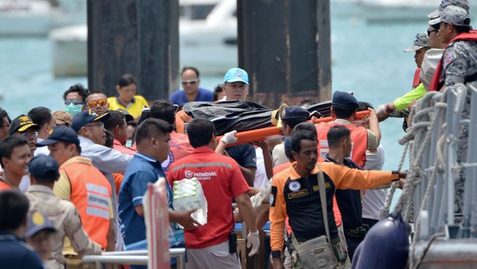 Záchranáři vynášejí na palubu tělo jedné z obětí potopené turistické lodi v Pchúketu.