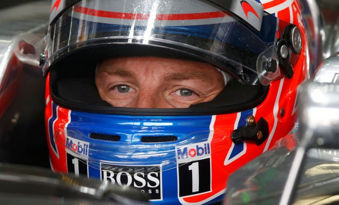 McLaren Formula One driver Jenson Button of Britain sits in his car at the pit lane during the first practice session of the Malaysian F1 Grand Prix at Sepang Internation