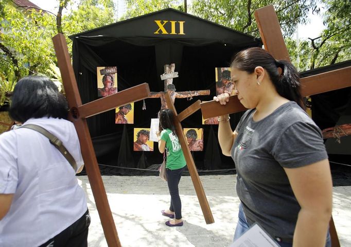 Catholic devotees carry crosses to one of the Stations of the Cross while doing the "Visita Iglesia", a traditional custom of visiting one, seven, or 14 churches and praying on Maundy Thursday, at a church in Quezon City in Metro Manila March 28, 2013. Holy Week is celebrated in many Christian traditions during the week before Easter. REUTERS/Cheryl Ravelo (PHILIPPINES) Published: Bře. 28, 2013, 12:48 odp.