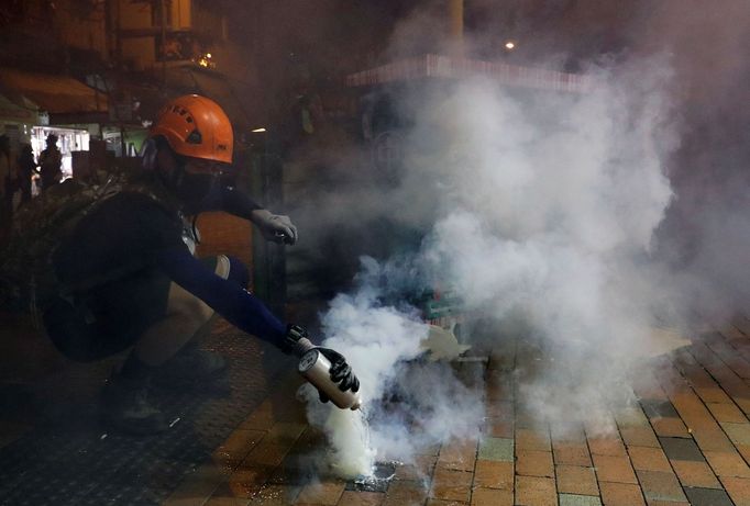 Policie v Hongkongu použila slzný plyn. Jeden z demonstrantů se snaží nádobu odhodit.