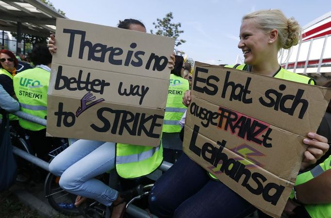 Members of German air carrier Lufthansa cabin crew union "UFO" hold placards outside a Lufthansa office building at the Fraport airport in Frankfurt, September 4, 2012. Lufthansa passengers face widespread flight disruption after cabin crew representatives said they continue a series of strikes over pay and cost-cutting measures at Germany's largest airline. The UFO union, which represents around two-thirds of Lufthansa's 19,000 cabin crew, late on Thursday called on its members to strike on Tuesday in Frankfurt and Berlin. REUTERS/Kai Pfaffenbach (GERMANY - Tags: BUSINESS EMPLOYMENT CIVIL UNREST TRANSPORT)