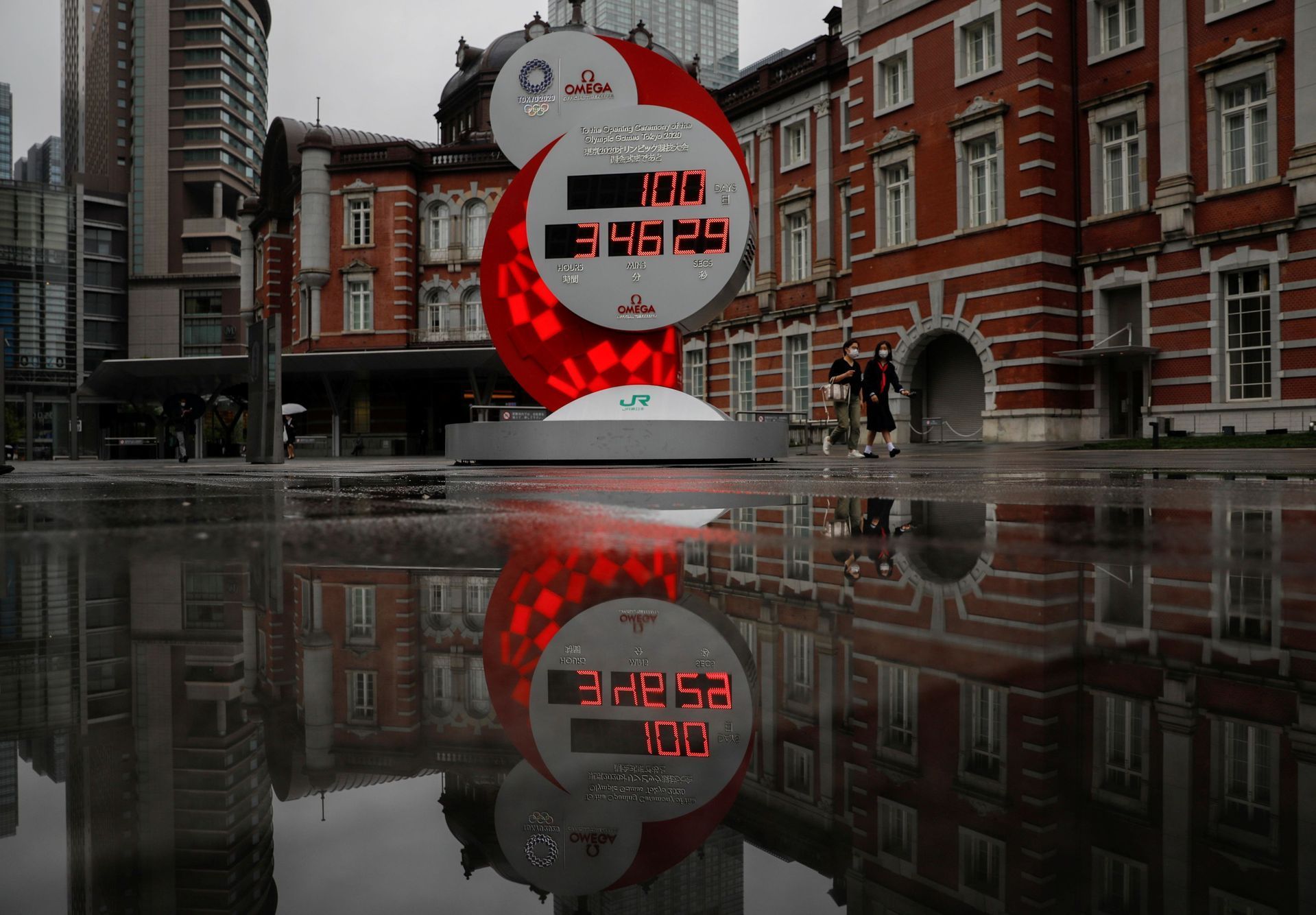 A countdown clock showing that 100 days are left until Tokyo 2020 Olympic Games is reflected in a puddle in Tokyo