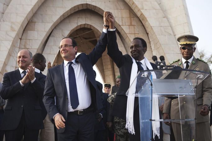 REFILE - CORRECTING IPTC CREDIT France's President Francois Hollande (2nd L) joins hands with Mali's interim president Dioncounda Traore after Traore spoke at Independence Plaza in Bamako, Mali February 2, 2013. France will withdraw its troops from Mali once the Sahel state has restored sovereignty over its national territory and a U.N.-backed African military force can take over from the French soldiers, Hollande said on Saturday. REUTERS/Joe Penney (MALI - Tags: POLITICS CONFLICT) Published: Úno. 2, 2013, 8:22 odp.