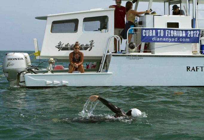 Team leader Bonnie Stoll, left, watches endurance swimmer Diana Nyad as she trains off Key West, Florida, August 13, 2012. Nyad, who turns 63 on August 22nd, plans to begin her fourth attempt to swim from Havana, Cuba, to the Florida Keys on Sunday, August 19, 2012. She says that severe jellyfish stings thwarted her third attempt and plans to wear the new suit during night time swimming. Photo taken August 13, 2012. REUTERS/Presley Adamson/Florida Keys News Bureau/Handout (UNITED STATES - Tags: SOCIETY) NO SALES. NO ARCHIVES. FOR EDITORIAL USE ONLY. NOT FOR SALE FOR MARKETING OR ADVERTISING CAMPAIGNS. THIS IMAGE HAS BEEN SUPPLIED BY A THIRD PARTY. IT IS DISTRIBUTED, EXACTLY AS RECEIVED BY REUTERS, AS A SERVICE TO CLIENTS Published: Srp. 16, 2012, 9:15 odp.