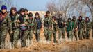 Female fighters of the Kurdish People's Protection Units (YPG) carry their weapons as they walk in the western countryside of Ras al-Ain