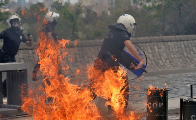 Pořádková policie utíká před ohněm během protestu v Ankaře, který vládu viní z důlního neštěstí.