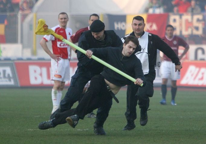 Přerušení utkání využil i fanoušek, který přelezl na hřiště, popadl rohový praporek a přebehl s ním až do středu hrací plochy.