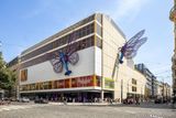 Motýli s barevnými křídly a tělem spitfiru před měsícem předznamenali otevření zrekonstruovaného bývalého obchodního domu na Národní třídě v centru Prahy. Teď je čekání skoro u konce.