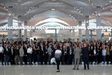 Zaměstnanci nového letiště se shromáždili před odletem prvního letadla po slavnostním otevření.