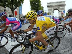 Španěl Alberto Contador (ve žlutém) projíždí v poslední etapě Tour de France kolem Vítězného oblouku v Paříži.