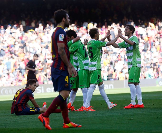 Getafe's players celebrate a goal against Barcelona's as Cesc Fabregas (front) walks pass during their La Liga soccer match at Camp Nou stadium in Barcelona May 3, 2014.