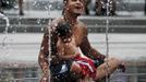 Jose Sanchez Sr. and his son Jose Jr. cool off in a fountain on the Rose Kennedy Greenway on a hot summer day in Boston, Massachusetts June 21, 2012. A heat wave blanketed the U.S. Mid-Alantic and Northeast Thursday, sparking brownouts in New York City and forcing utilities across the region to ask customers to conserve electricity. REUTERS/Brian Snyder (UNITED STATES - Tags: ENVIRONMENT ENERGY SOCIETY)