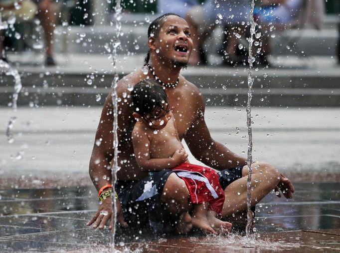 Jose Sanchez Sr. and his son Jose Jr. cool off in a fountain on the Rose Kennedy Greenway on a hot summer day in Boston, Massachusetts June 21, 2012. A heat wave blanketed the U.S. Mid-Alantic and Northeast Thursday, sparking brownouts in New York City and forcing utilities across the region to ask customers to conserve electricity. REUTERS/Brian Snyder (UNITED STATES - Tags: ENVIRONMENT ENERGY SOCIETY)