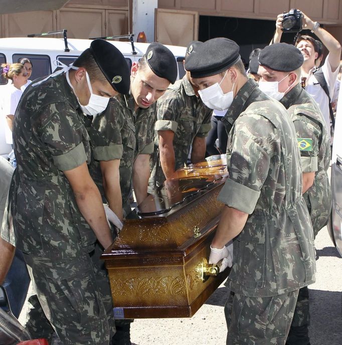 Army soldiers carry a coffin containing the body of a victim of the fire at Boate Kiss nightclub in the southern city of Santa Maria, 187 miles (301 km) west of the state capital of Porto Alegre, January 27, 2013. A fire in a nightclub killed at least 245 people in southern Brazil on Sunday when a band's pyrotechnics show set the building ablaze and fleeing patrons were unable to find the emergency exits in the ensuing panic, officials said. The blaze in the southern city of Santa Maria was started when a band member or someone from its production team ignited a flare, which then set fire to the ceiling, said Luiza Sousa, a civil police official. The fire spread "in seconds," she said. An estimated 500 people were in the Boate Kiss nightclub when the fire broke out early on Sunday, and many were unable to find the exits as dark smoke quickly filled the room. At least one exit was locked, trapping hundreds inside to die, many from asphyxiation as they inhaled smoke, police said. REUTERS/Edison Vara (BRAZIL - Tags: DISASTER MILITARY) Published: Led. 27, 2013, 7:57 odp.