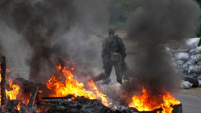 Proruští separatisté na jednom z kontrolních stanovišť ve Slavjansku. Kvůli postupu ozbrojených složek zapálili pneumatiky. (Květen 2014).