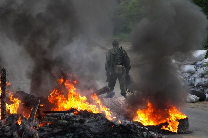 Proruští separatisté na jednom z kontrolních stanovišť ve Slavjansku. Kvůli postupu ozbrojených složek zapálili pneumatiky. (Květen 2014).