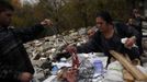 Mateo Echevarria watches as relatives prepare lunch after a bulldozer demolished two homes at the Spanish gypsy settlement of Puerta de Hierro, in the outskirts of Madrid November 20, 2012. Fifty-four families have been living in Puerta de Hierro, on the banks of the Manzanares river for over 50 years. Since the summer of 2010, the community has been subject to evictions on the grounds that the dwellings are illegal. Families, whose homes have been demolished, move in with relatives whose houses still remain while the debris keeps piling up around them as more demolitions take place. REUTERS/Susana Vera (SPAIN - Tags: CIVIL UNREST BUSINESS CONSTRUCTION) Published: Lis. 20, 2012, 5:10 odp.