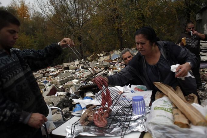 Mateo Echevarria watches as relatives prepare lunch after a bulldozer demolished two homes at the Spanish gypsy settlement of Puerta de Hierro, in the outskirts of Madrid November 20, 2012. Fifty-four families have been living in Puerta de Hierro, on the banks of the Manzanares river for over 50 years. Since the summer of 2010, the community has been subject to evictions on the grounds that the dwellings are illegal. Families, whose homes have been demolished, move in with relatives whose houses still remain while the debris keeps piling up around them as more demolitions take place. REUTERS/Susana Vera (SPAIN - Tags: CIVIL UNREST BUSINESS CONSTRUCTION) Published: Lis. 20, 2012, 5:10 odp.