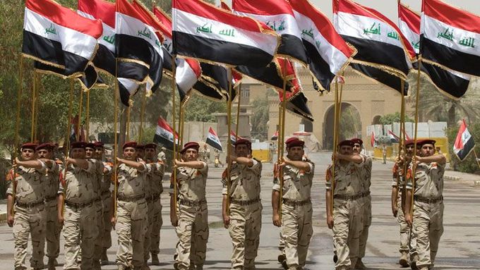 Iráčtí vojáci pochodují při předávání budovy starého ministerstva obrany v Bagdádu.