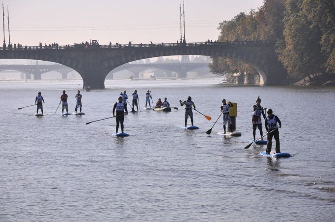 Paddleboarding. Tito vodáci plují na prknech, která jsou podobná těm, co mívají surfaři. Vpřed se pohybují pomocí dlouhého pádlä, aby dosáhli do vody ze stoje.