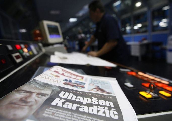 A worker checks the new issue of the day's newspaper, featuring Radovan Karadzic on the front page, in Belgrade July 22, 2008. Karadzic, one of the world's most wanted men, has been arrested, a statement from the office of Serbian President Boris Tadic said on Monday. The headline reads: "Karadzic arrested". REUTERS/Marko Djurica (SERBIA)