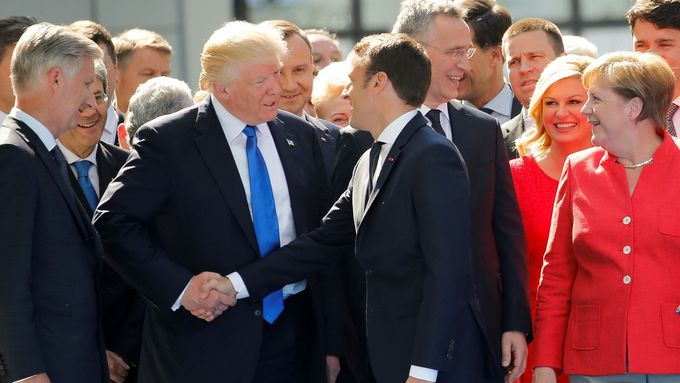 Snad až příliš vřelý stisk rukou Trump vs. Macron, jeden z pozoruhodných společenských okamžiků summitu NATO.