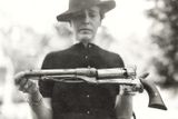 Žena držící perkusní revolver.