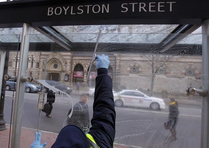 A man washes a bus stop window on Boylston Street after the street reopened to the public for the first time since the Boston Marathon bombings in Boston, Massachusetts April 24, 2013. REUTERS/Jessica Rinaldi (UNITED STATES - Tags: CRIME LAW CIVIL UNREST) Published: Dub. 24, 2013, 12:40 odp.