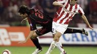 Kaká z AC Milán (vlevo) padá v souboji s hráčem Crvena Zvezdy Bělehrad Dejanem Milovanovičem.