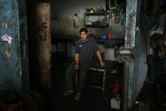 Palestinian Abed al-Majeed Reheem, 18, poses for a photograph in a car repair garage in Gaza City May 30, 2013. Reheem left school to work as an apprentice in the garage so that he could support his family's income. Apprentice mechanics earn around $100 per month, garage owners said. REUTERS/Mohammed Salem (GAZA - Tags: TRANSPORT SOCIETY BUSINESS EMPLOYMENT PORTRAIT) Published: Kvě. 30, 2013, 12:54 odp.