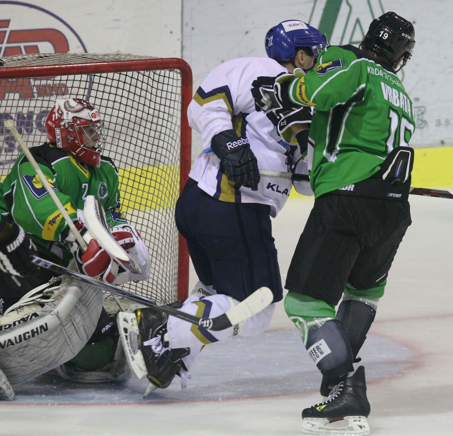 Mladoboleslavští hokejisté Vlastimil Lakosil (brankář) a David Vrbata se snaží bránit kladenského útočníka v přípravném utkání před sezónou 2012/13.