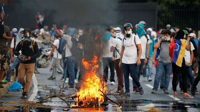 Demonstranti stavěli na silnicích v Caracasu barikády a pálili pneumatiky.