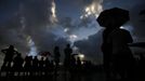 Rain showers fall as tourists look at a cloudy sky as a full solar eclipse begins in the northern Australian city of Cairns November 14, 2012. REUTERS/Tim Wimborne (AUSTRALIA - Tags: SOCIETY ENVIRONMENT) Published: Lis. 13, 2012, 9:35 odp.