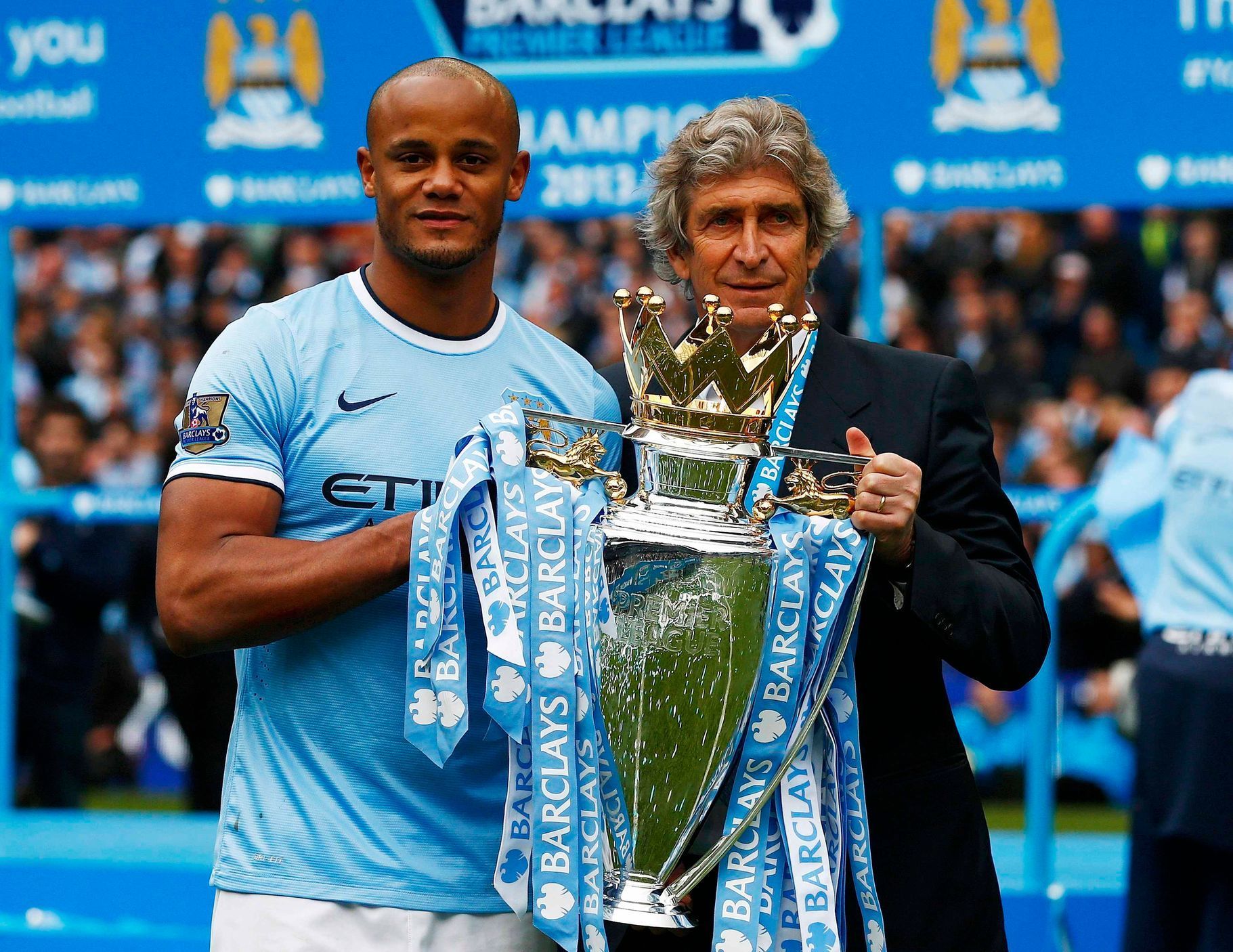 Manchester City's Kompany and manager Manuel Pellegrini pose for pictures with the English Premier League trophy following their soccer match against West Ham United at the Etihad Stadium in Mancheste