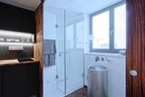 Samostatné WC a prostorný sprchový kout doplňuje umyvadlo v podobě barelu, který je možné otevřít a využít jako úložný prostor.