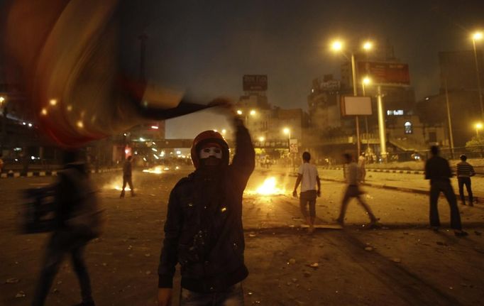 An anti-Mursi protester waves a national flag during clashes with members of the Muslim Brotherhood and ousted Egyptian President Mohamed Mursi supporters, along a road at The Ramsis square which leads to Tahrir Square, during a celebration marking Egypt's 1973 war with Israel, in Cairo October 6, 2013. At least 33 people were killed during protests in Egypt on Sunday, the interior ministry said, as the crisis since the army seized power three months ago showed no sign of abating.