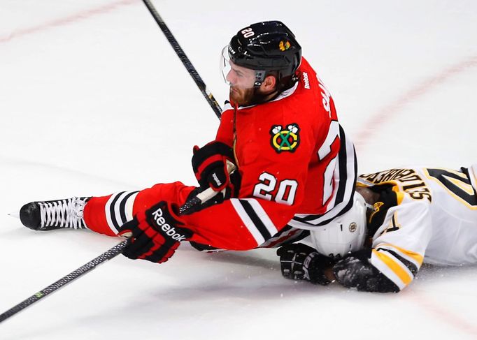 Chicago Blackhawks' Brandon Saad (20) falls on Boston Bruins' Dennis Seidenberg during the second period in Game 2 of their NHL Stanley Cup Finals hockey series in Chicag