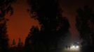 People walk on a road near a forest fire burning in Ribeira do Farrio, near Ourem September 3, 2012. According to the civil defence, over 1,700 firefighters have been mobilized to tackle more than 10 forest fires currently active in Portugal. A man died and three people were injured so far. REUTERS/Rafael Marchante (PORTUGAL - Tags: DISASTER ENVIRONMENT) Published: Zář. 4, 2012, 12:36 dop.