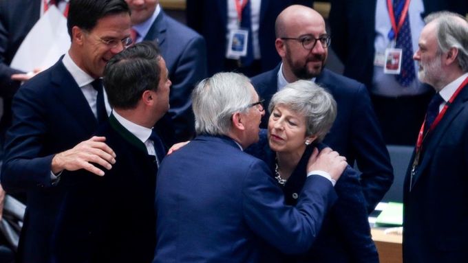 Šéf Evropské komise Jean-Claude Juncker se vítá s britskou premiérkou Theresou Mayovou na summitu EU v Bruselu.