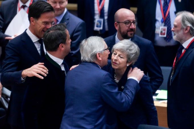 Šéf Evropské komise Jean-Claude Juncker se vítá s britskou premiérkou Theresou Mayovou na summitu EU v Bruselu.