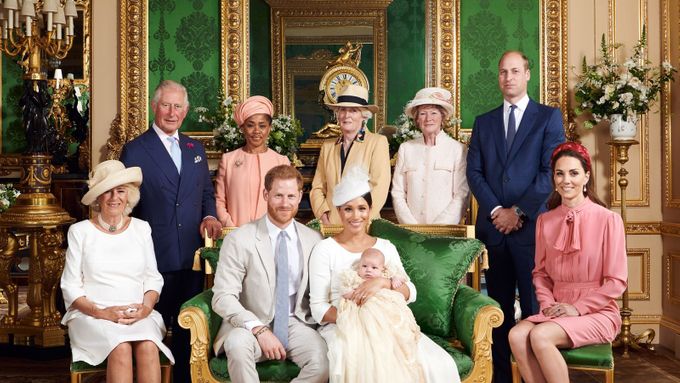 Malý Archie obklopený rodiči Harrym a Meghan a dalšími příbuznými. Na sobě má křestní roucho, tedy repliku oděvu, který byl vyroben pro nejstarší dceru královny Viktorie.