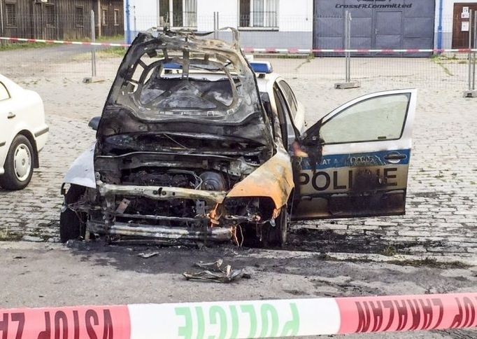 Policejní auto zapálené uskupením Síť revolučních buněk.