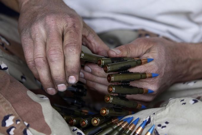 Kent Josephso organizes his 8mm tracer rounds during the Big Sandy Shoot in Mohave County, Arizona March 23, 2013. The Big Sandy Shoot is the largest organized machine gun shoot in the United States attended by shooters from around the country. Vintage and replica style machine guns and cannons are some of the weapons displayed during the event. Picture taken March 22, 2013. REUTERS/Joshua Lott (UNITED STATES - Tags: SOCIETY) Published: Bře. 25, 2013, 3:35 odp.