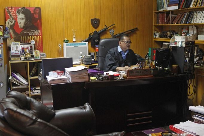 Jaime "Jimmy" Santiago, a lower court judge in Manila, works inside his room before hearing a case at the Regional Trial Court in Manila March 5, 2013. Santiago, a former police officer who headed the Special Weapons and Tactics (SWAT) unit, favours arming Filipino judges to protect themselves from disgruntled litigants and criminal syndicates whose members were sent to jail. There have been recent cases of deadly courtroom shootings in the Philippines. REUTERS/Romeo Ranoco (PHILIPPINES - Tags: POLITICS CRIME LAW) Published: Dub. 4, 2013, 10:40 dop.