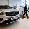 A man walks past a car produced by Chinese automobile manufacturer Geely at a dealership in Moscow