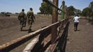 Nadav (R), the chief cowboy of the Yonatan herd, walks next to Israeli soldiers on a ranch just outside Moshav Yonatan, a collective farming community, about 2 km (1 mile) south of the ceasefire line between Israel and Syria in the Golan Heights May 21, 2013. The group of cowboys, who have been running the ranch on the Golan's volcanic rocky plateau for some 35 years, also host the Israeli military, who use half of the cattle farm, 20,000 dunams (5,000 acres), as a live-fire training zone. Israel captured the Golan Heights from Syria in the 1967 Middle East war and annexed the territory in 1981, a move not recognized internationally. Picture taken May 21, 2013. REUTERS/Nir Elias (ENVIRONMENT ANIMALS SOCIETY) ATTENTION EDITORS: PICTURE 14 OF 27 FOR PACKAGE 'COWBOYS GOLAN HEIGHTS' SEARCH 'COWBOY GOLAN' FOR ALL Published: Kvě. 29, 2013, 10:06 dop.