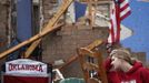 Resident Taylor Tennyson sits in the front yard of her family home which was left devastated by a tornado in Moore, Oklahoma, in the outskirts of Oklahoma City May 21, 2013. Rescuers went building to building in search of victims and thousands of survivors were homeless on Tuesday, a day after a massive tornado tore through a suburb of Oklahoma City, wiping out whole blocks of homes and killing at least 24 people. REUTERS/Adrees Latif (UNITED STATES - Tags: DISASTER ENVIRONMENT TPX IMAGES OF THE DAY) Published: Kvě. 21, 2013, 9:46 odp.