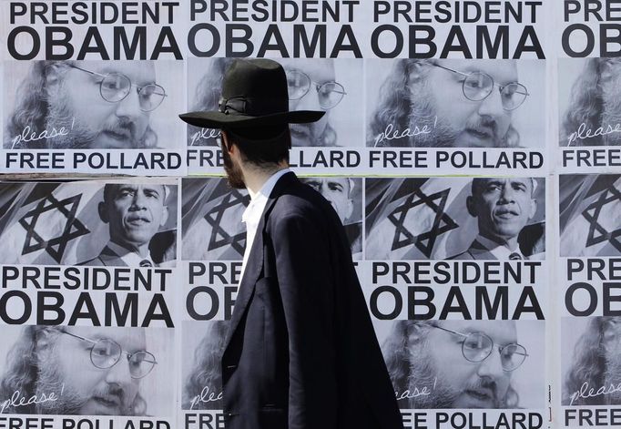 An ultra-Orthodox Jewish man walks past posters calling for U.S. President Barack Obama to free Jonathan Pollard from a U.S. prison, in Jerusalem March 20, 2013. Obama arrives in Israel on Wednesday without any new peace initiative to offer disillusioned Palestinians and facing deep Israeli doubts over his pledge to prevent a nuclear-armed Iran. Pollard, a former U.S. Navy intelligence analyst, has been serving a life sentence in the United States since he was caught spying for Israel in the 1980s. REUTERS/Baz Ratner (JERUSALEM - Tags: POLITICS) Published: Bře. 20, 2013, 8:27 dop.