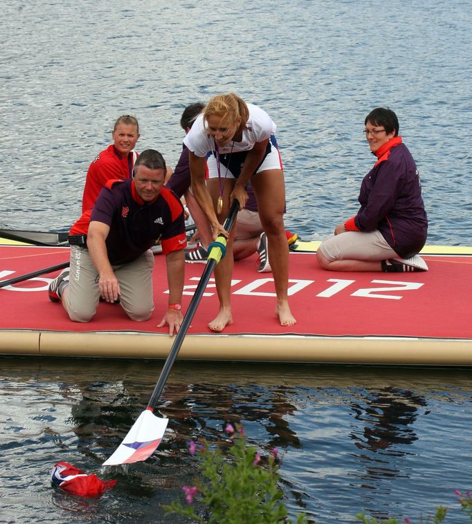 Česká veslařka Miroslava Knapková (uprostřed) slaví zlatou medaili a loví z vody českou vlajku na OH 2012 v Londýně.